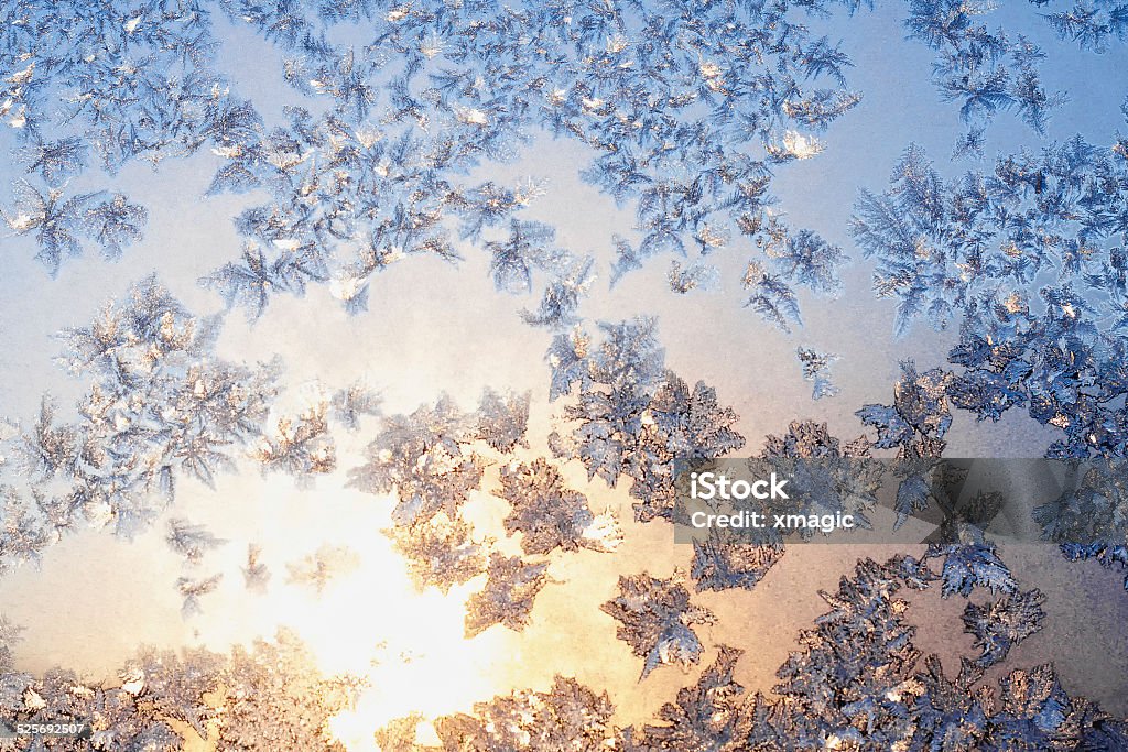 Frost and snowflakes on frozen window Sun lights on the ice snowflakes on christmas winter frozen window. Natural color. Selective focus of image Abstract Stock Photo