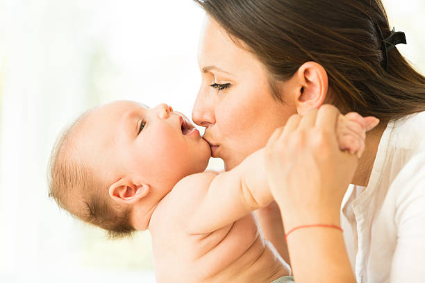 istock Mother kissing her baby boy 525694627