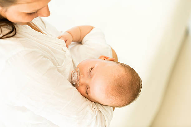 istock Baby boy sleeping in mother's arms 525715739