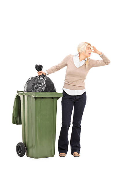 istock Disgusted woman standing next to a trash can 525719339