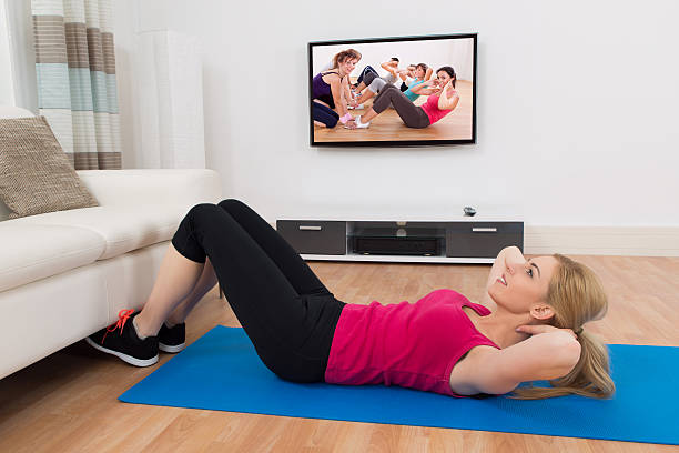 istock Woman Exercising In Front Of Television 525725372