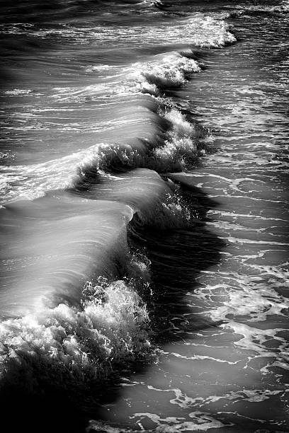 The sea in black and white.  Dramatic waves or surf crashing ashore.