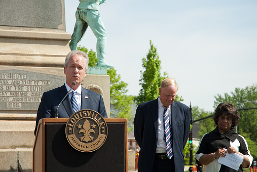 Louisville, KY, United States - April 29, 2016: Mayor Greg Fischer announces plans to remove a Confederate monument from South Third Street, near the University of Louisville campus. University president James Ramsey and another official stand behind the mayor.