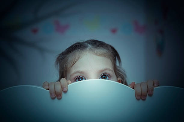 scared little girl in her bed stock photo