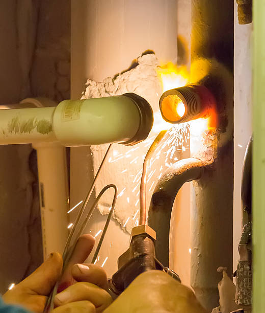 The plumber makes gas welding of a pipe stock photo