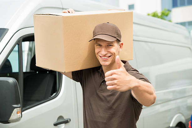 istock Delivery Man With Cardboard Boxes Showing Thumbs up Sign 525738850