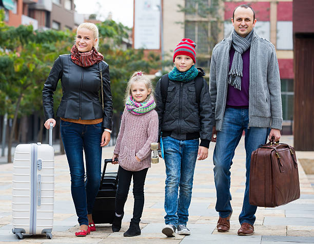 istock Family journey: spouses with children walking and luggage 525738988