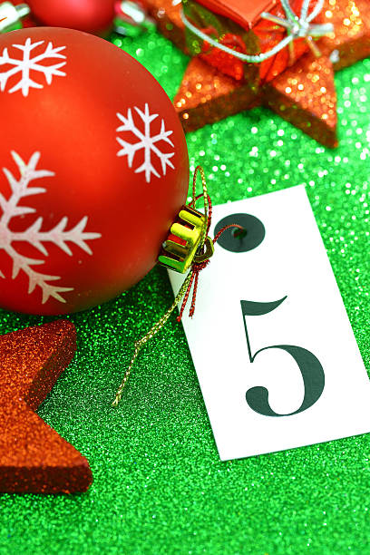 istock Number five on tag and Christmas ornamets on green background 525739515
