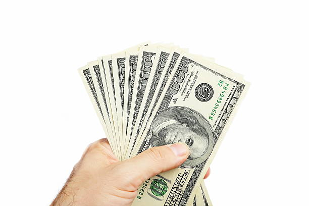 istock Male hand holding one hundred dollar bill 525739618