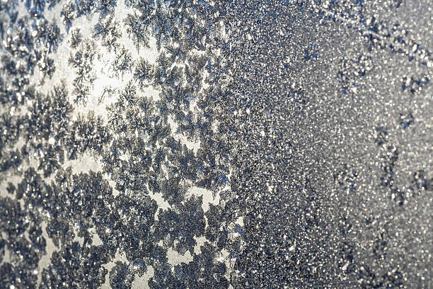istock Snowflakes and ice on frozen window 525740525
