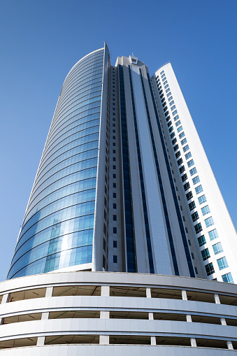 Manama, Bahrain - November 21, 2014: Diplomat Commercial Office Tower in Manama city. Shining scyscrapper on blue sky background