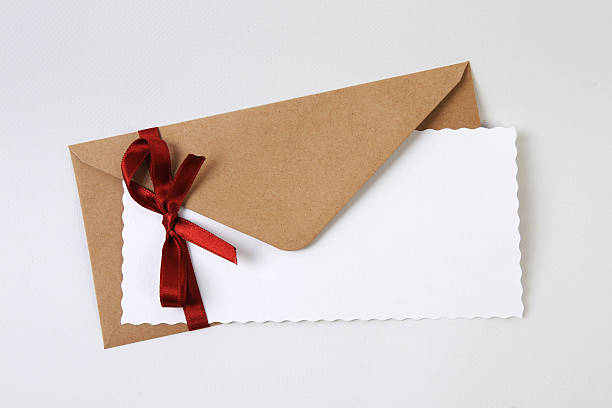 istock Brown envelope with paper sheet and red ribbon 525754743