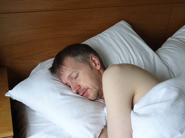istock Image of naked man asleep in bed, sleeping, snoring, stubble-beard 525755557