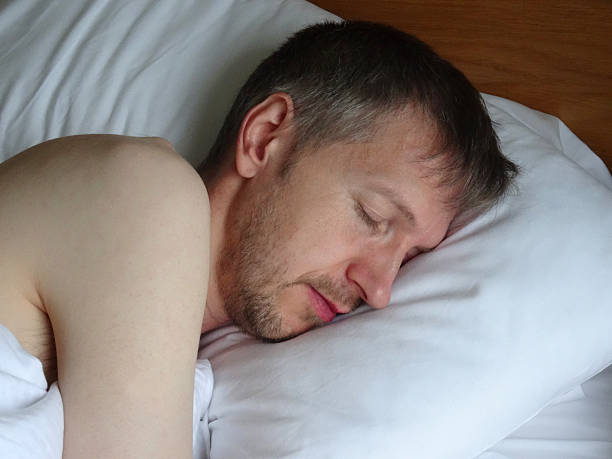 istock Image of naked man asleep in bed, sleeping, snoring, stubble-beard 525755559
