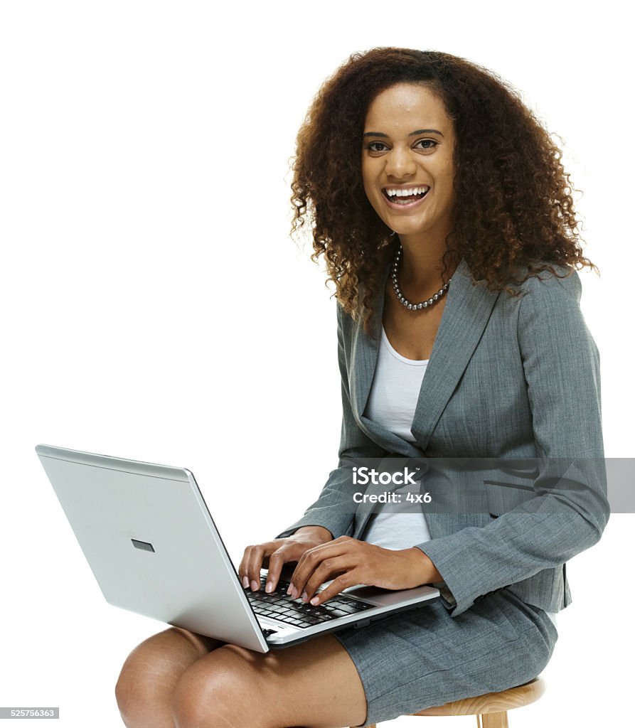 Cheerful businesswoman working on laptop Cheerful businesswoman working on laptophttp://www.twodozendesign.info/i/1.png 20-29 Years Stock Photo