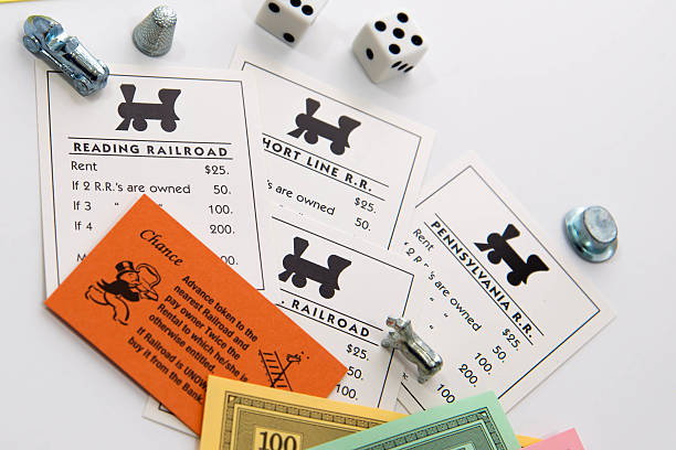 ferrocarril de monopolio de tarjetas, piezas, dinero y dados - monopoly board game leisure games train board game fotografías e imágenes de stock