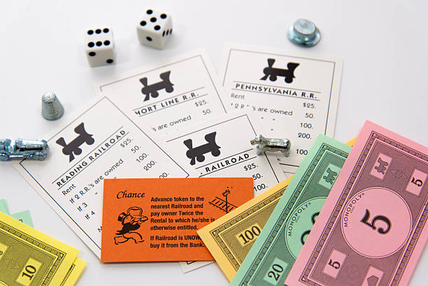ferrocarril de monopolio de tarjetas, piezas, dinero y dados - monopoly board game leisure games train board game fotografías e imágenes de stock