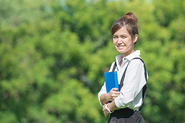 istock Female student outdoors holding a notebook and smiling 525770505