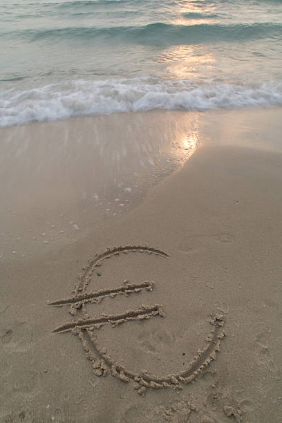 istock Dollar sign in the sand being washed away 525771187