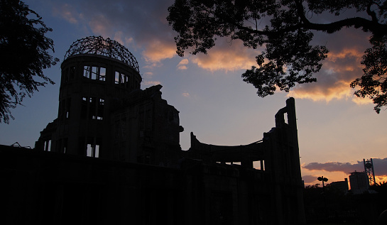 The famous Atomic Bomb Dome (or A-Bomb Dome) in the Hiroshima Peace Memorial Park at Sunset. The Dome building was built in 1915 and almost completely destroyed by the world's first atomic bomb - named Little Boy - to be used in war in 1945. The building was a mere 160 meters from the bomb's hypocenter.  