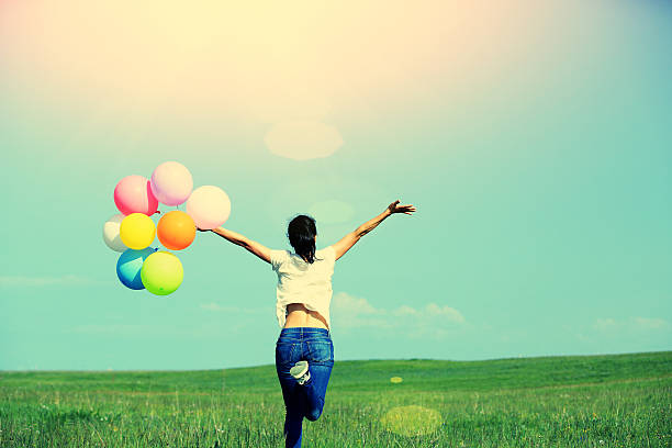 istock young asian woman  with colored balloons 525773449