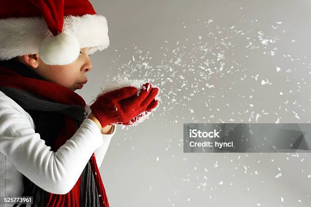 Boy In Santa Claus Hat Blowing Snowflakes Stock Photo - Download Image Now - Christmas, Child, Wishing