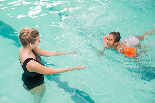 istock Cute little girl learning to swim with coach 525788159
