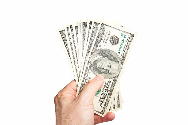 istock Male hand holding one hundred dollar bill 525800968