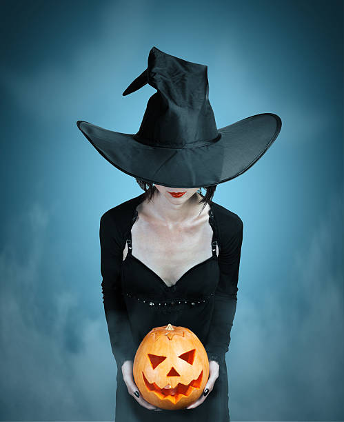 istock Mystery witch with Halloween pumpkin 525801239