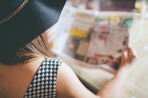 istock back view of woman reading a newspaper 525801588