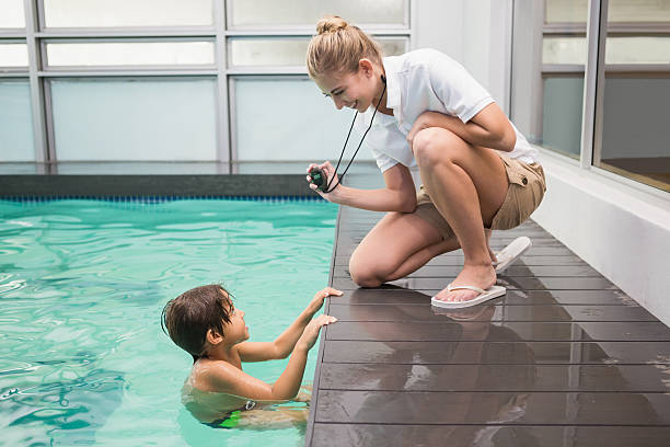 istock Pretty swimming coach showing boy his time 525802091