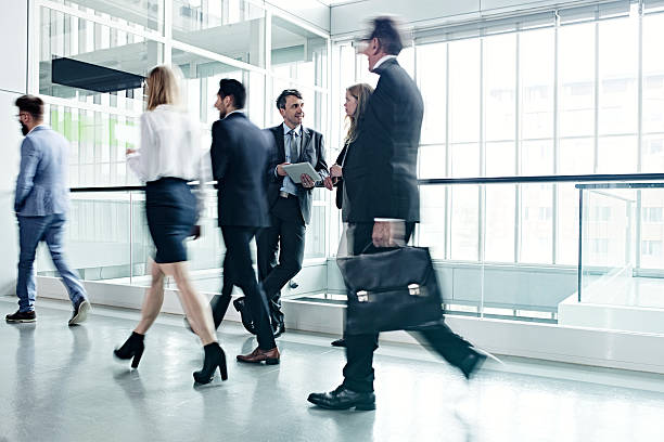 istock Business people walking in office lobby 525802442