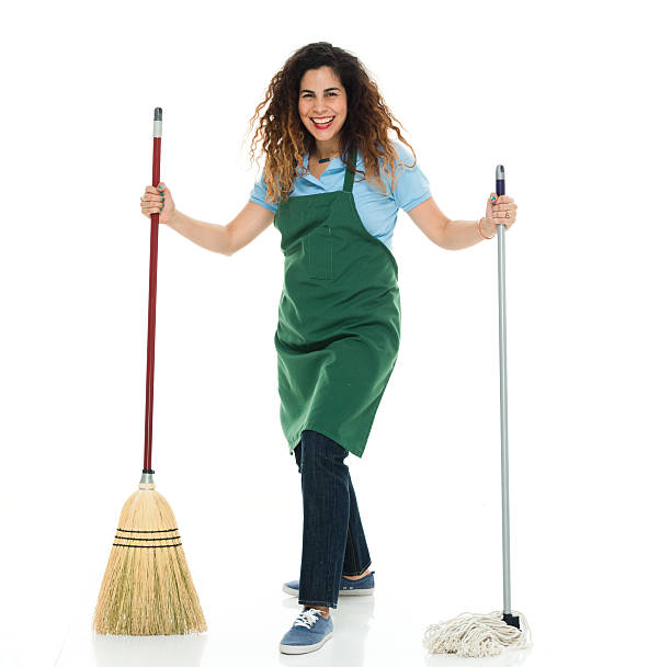 istock Smiling janitor holding mop and broom 525802516
