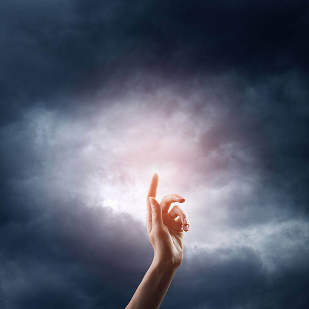 istock religion concept. finger touching the magic sky 525804149