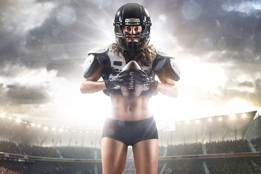 American football female player posing with ball