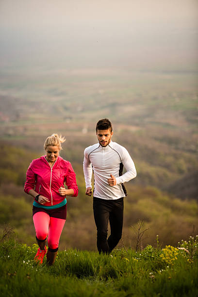 istock Couple runs along mountain field 525810536