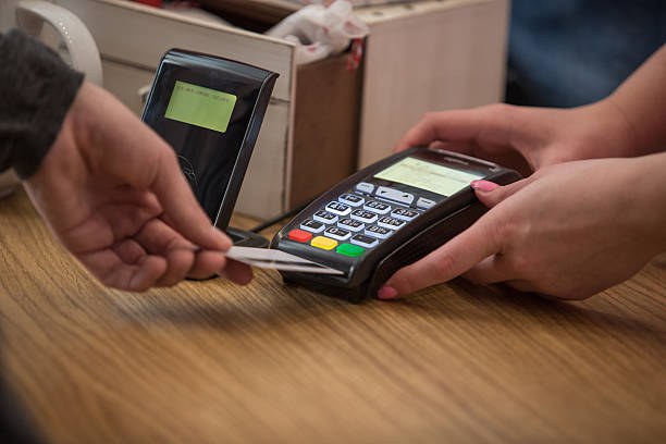 istock Man at counter paying with credit card 525810662