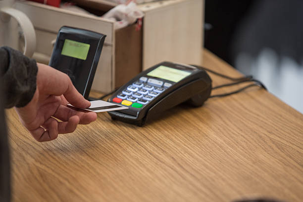 istock Man at counter paying with credit card 525810672