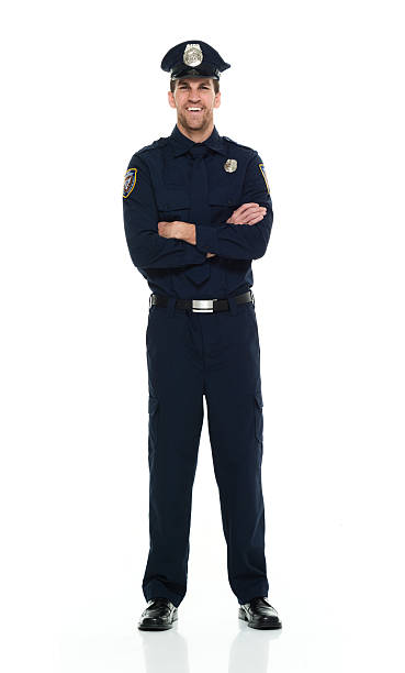 istock Smiling police standing with arms crossed 525811014