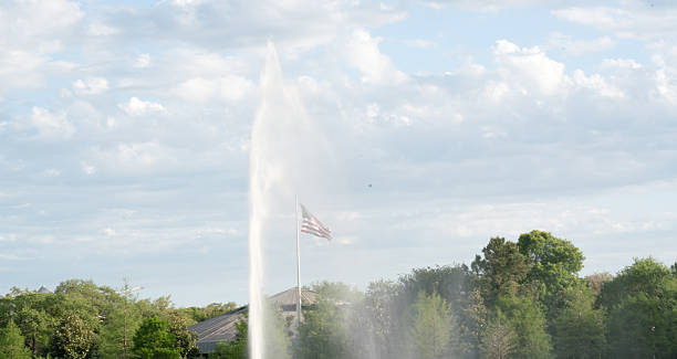 istock spraying fountain with American flag and sunny sky 525814570