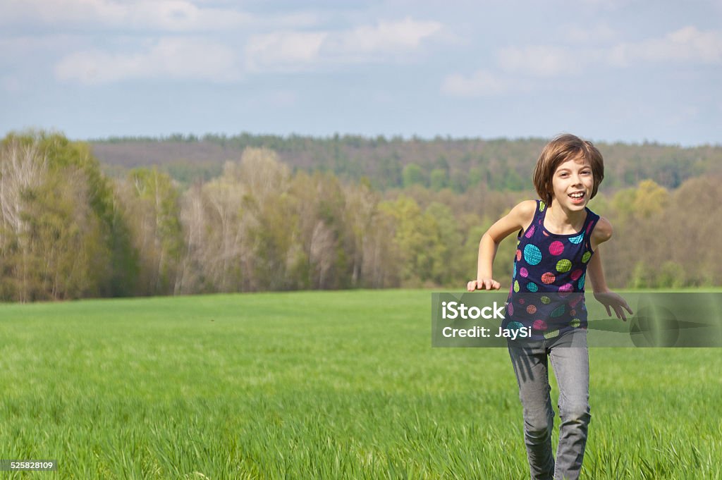 Happy active girl running on green field Happy active girl running on green field. Child and nature in spring, summer Activity Stock Photo