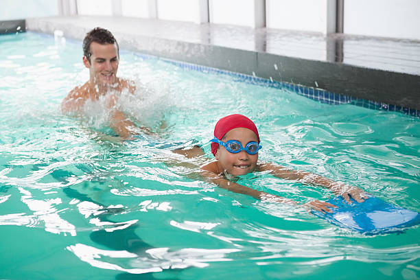 istock Cute little boy learning to swim with coach 525829451