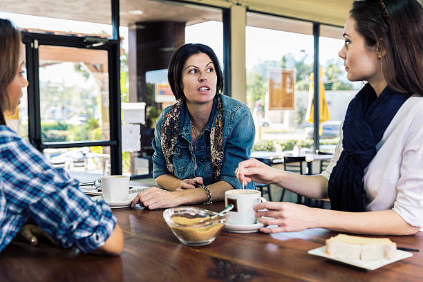 mulheres depois de uma boa conversa bebericando uma xícara de café - coffee shop people discussion three people - fotografias e filmes do acervo