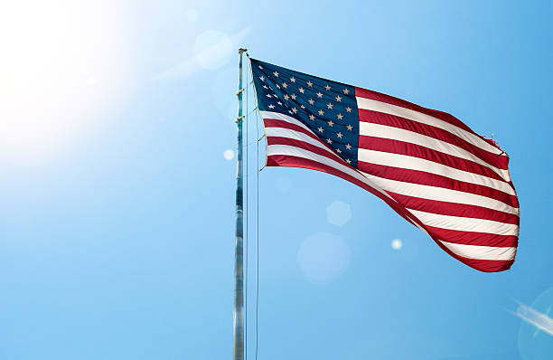 istock American National Flag on Pole With Sunlight Effect 525832139