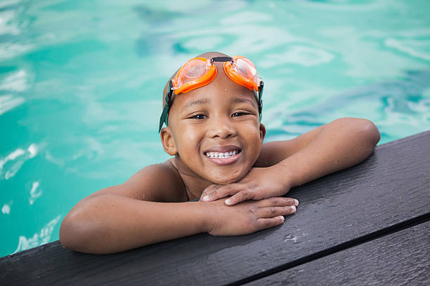 rapaz sorridente na piscina - swimming goggles imagens e fotografias de stock