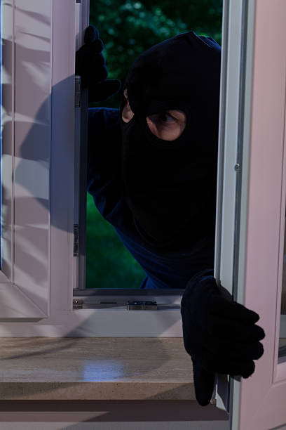 istock Burglar opening the window 525832315