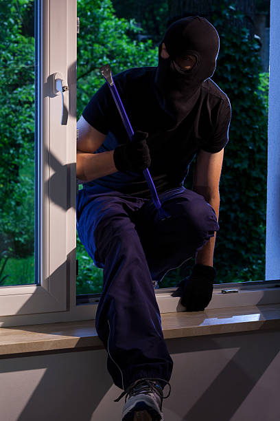 istock Thief with crowbar in house 525832317