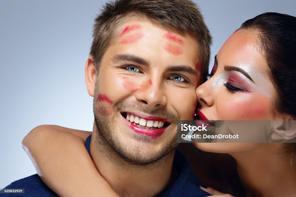 Beautiful woman kissing happy man Beautiful woman kissing happy man over blue background Adult Stock Photo