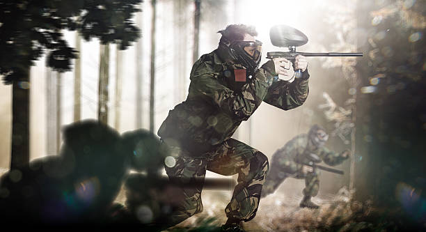 istock Paintball team in action forest location 525833235