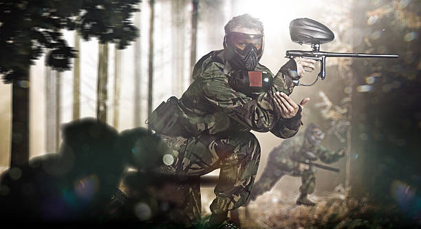 istock Paintball team in action forest location 525833237